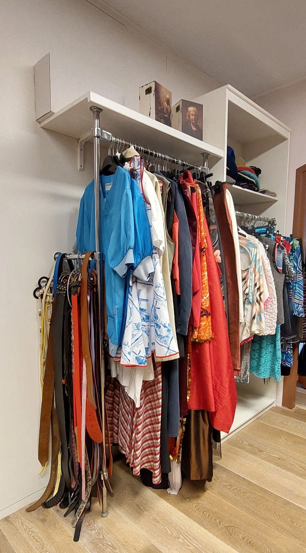 Riemen en accessoires naast een kledingrek